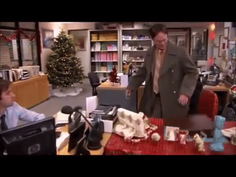 Dwight Schrute de The Office assis sur une chaise emballée dans un cadeau uniquement pour qu'elle s'effondre